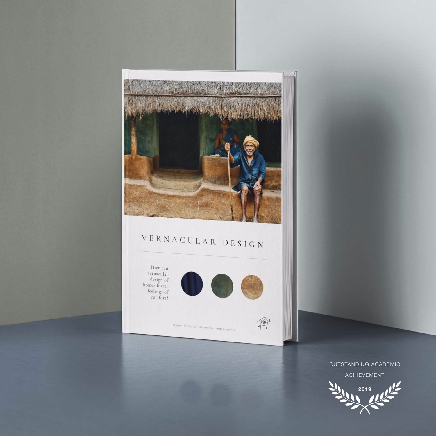 The Vernacular Design dissertation as a printed book, standing on end, its cover a photograph of a thatched Kerala homestead