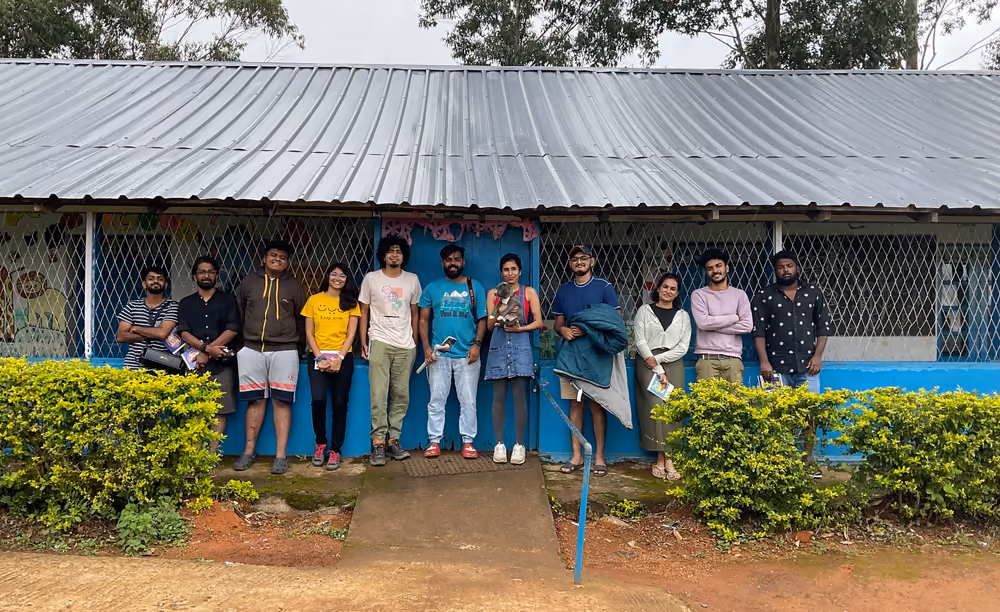 The group lined up outside a tin-roofed building, notebooks in hand.