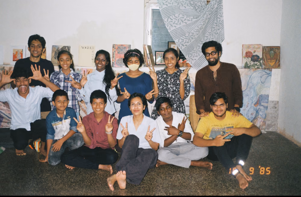 A group photo indoors at the end of a session, everyone throwing peace signs.